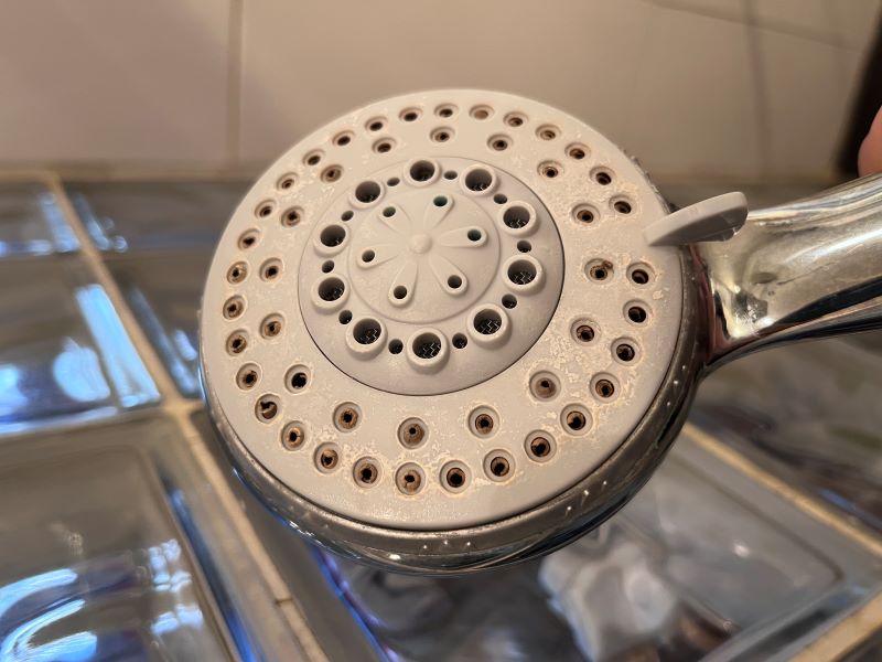 Installation adoucisseur d'eau : pommeau de douche bouché par le calcaire